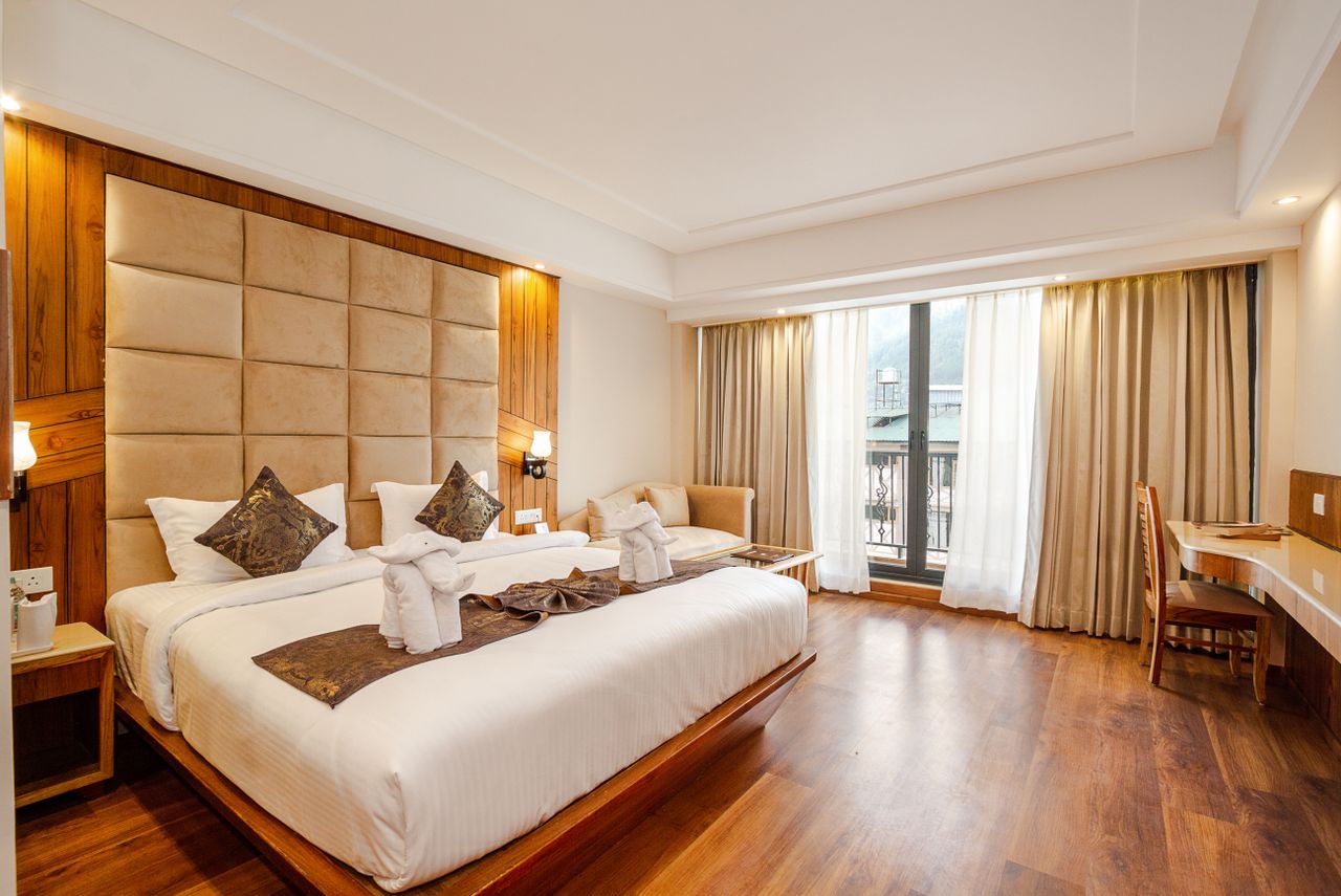 portfolio-02 Spacious and elegant hotel room with a king-size bed and large window view.