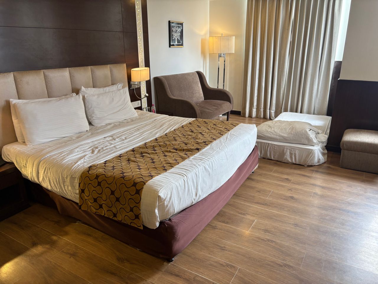 why-choose-us A chic hotel room featuring a comfortable bed, modern furniture, and soft lighting.