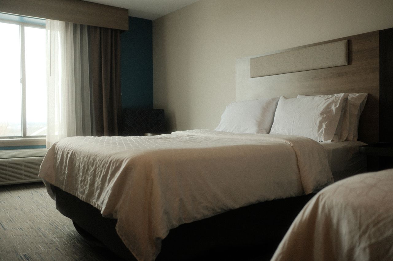 portfolio-05 Peaceful hotel room with luxurious bedding, perfect for a relaxing stay and comfortable sleep.